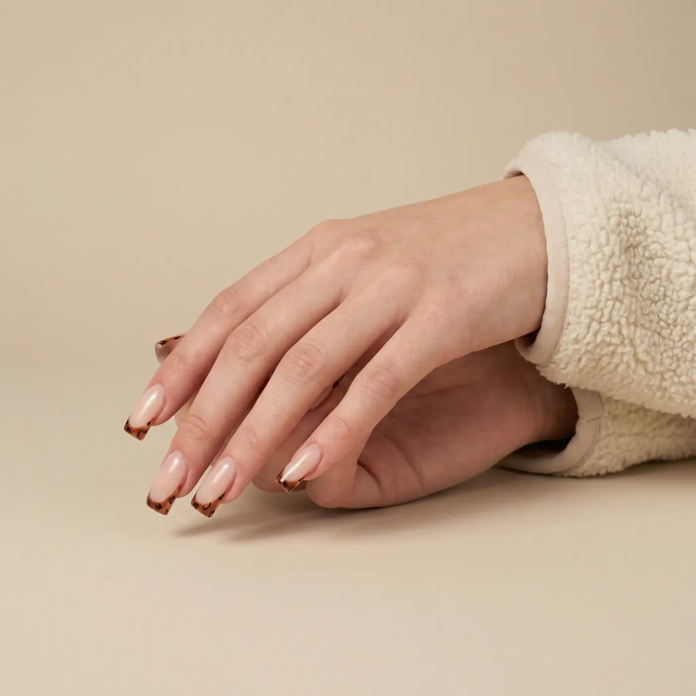 Lange nude negler med brune leopardmønstrede french-tupper, negleforlengelse med flytende gel